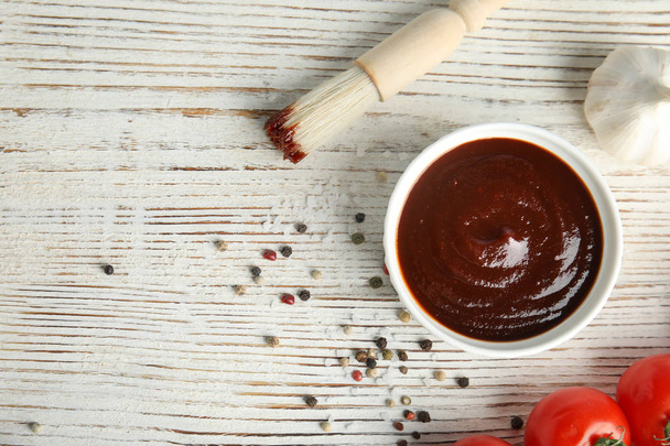 Flat lay composition with barbecue sauce on white wooden table. Space for text - 写真・画像