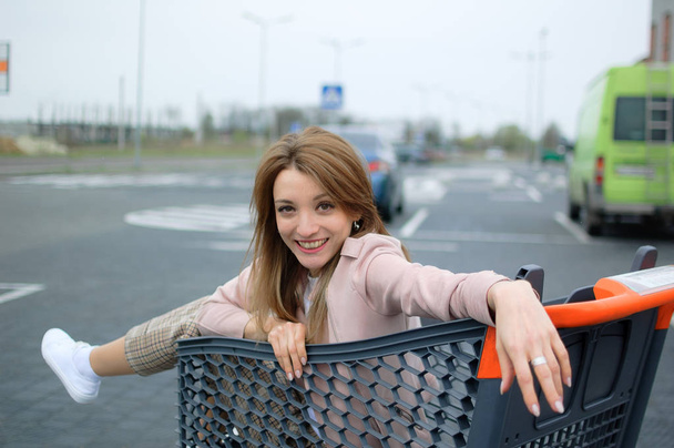 Krásná dívka na vozíku poblíž supermarketu. Venkovní - Fotografie, Obrázek