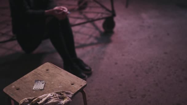 gefüllte Spritze auf einen Tisch werfen, auf dem eine drogenabhängige rothaarige kaukasische weiße junge Frau mit schwarzem Pullover, Rock und Chocker herumläuft - Angst, Depression und Gefahrengefühl - Filmmaterial, Video