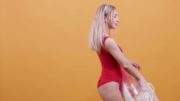 Blond młoda kobieta z pierścieniem pływackiej tańce w zwolnionym tempie - Materiał filmowy, wideo