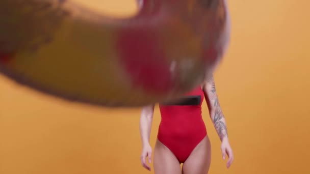 Blonde young woman in swimwear catches a swim ring and dances - Materiał filmowy, wideo