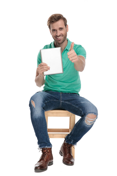 сидящий современный человек показывает хороший жест с табличкой в руке
 - Фото, изображение