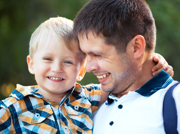 Щасливий батько і його син розважаються в парку
 - Фото, зображення