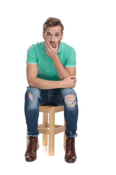 sedící překvapený muž s rukama nad bradou - Fotografie, Obrázek