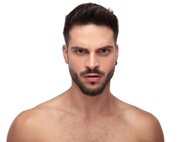 Wütender unbekleideter Typ, der mit hochgezogener Augenbraue aufgebracht wirkt - Foto, Bild