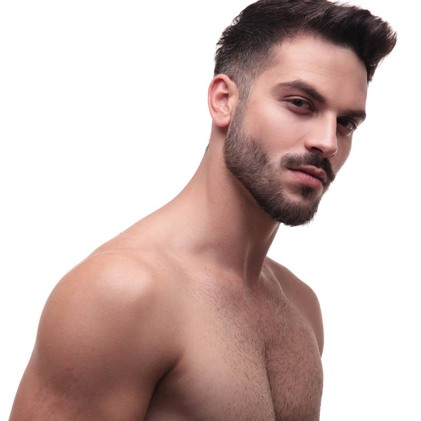 vista lateral de um homem despido com barba olhando encantador
  - Foto, Imagem