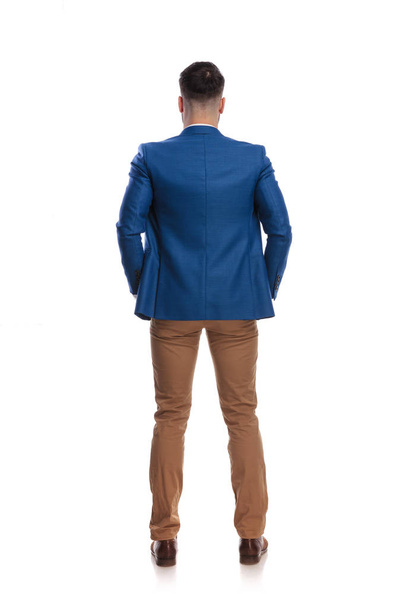 back view of a man standing with hands in pockets - Foto, Bild