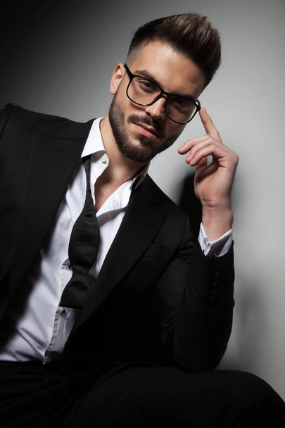 cara de negócios em smoking preto ajustando seus óculos
 - Foto, Imagem