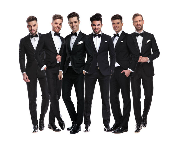 group of elegant young men in tuxedos  standing together  - Foto, afbeelding