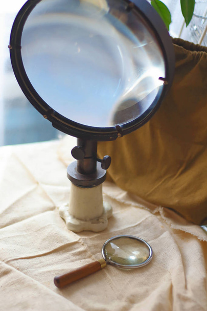 Iso ja pieni vintage vanha optinen suurennuslasien linssit kankaalle. Tieteen haun käsite
 - Valokuva, kuva