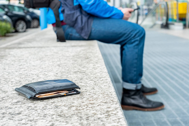 Το άτομο χάνει το πορτοφόλι του με μετρητά στο δρόμο της πόλης - Φωτογραφία, εικόνα