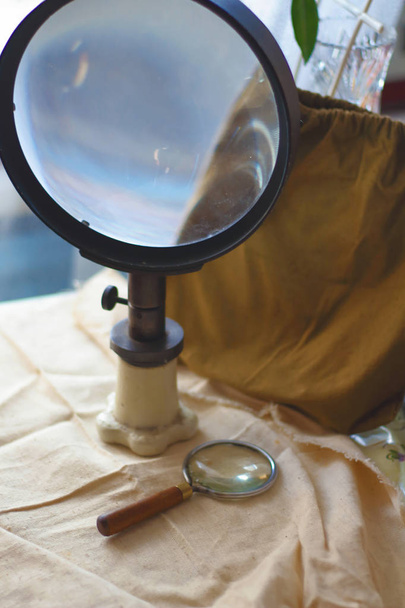 Большие и маленькие винтажные старые оптические лупы линзы на холсте ткани. Научный поиск
 - Фото, изображение