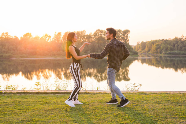 Concetto di danza romantica, sociale e popolare - giovane coppia che balla la bachata sullo sfondo del tramonto
 - Foto, immagini