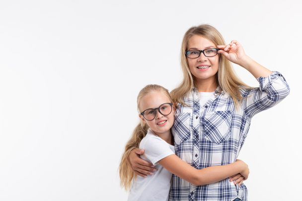 Portrait of mother and daughter with eyeglasses on white background - Фото, зображення