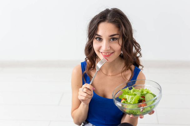 People, healthy lifestyle and fitness concept - Beautiful woman after workout eating healthy salad close up - Foto, Bild