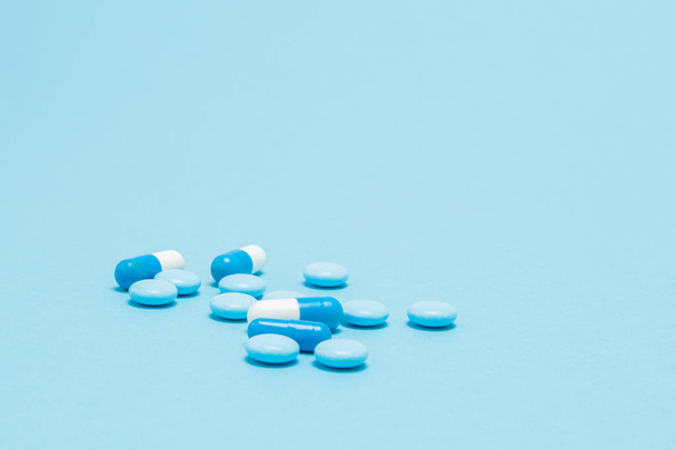 Scattered blue pills on blue table. Mock up for special offers a - 写真・画像