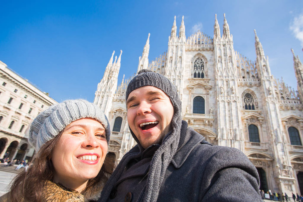 Travel, Italy and vacations concept - Happy tourists taking a self portrait in front of Duomo cathedral, Milan - Photo, Image