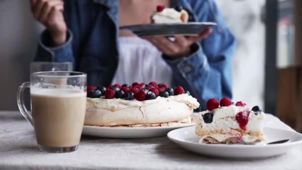 woman with cream pie with blueberries and raspberries on table - Materiaali, video