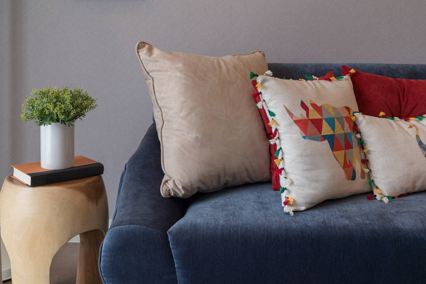сучасний синій диван з різнокольоровими подушками
 - Фото, зображення