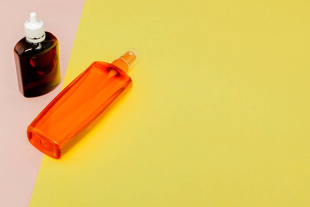 Bottle sunblock on bright square yellow and pink background. The - 写真・画像
