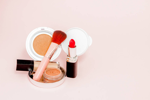 Make up products spilling on to a bright pink background with co - Photo, image