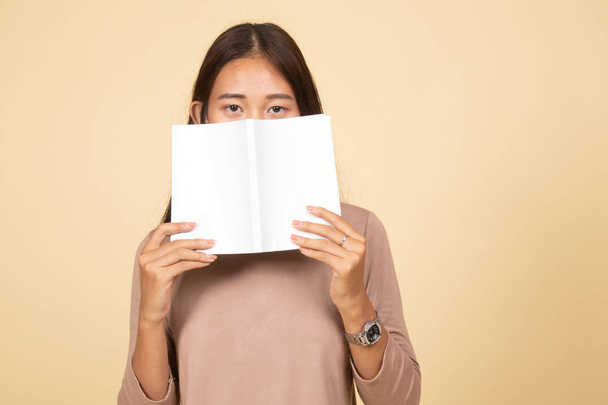 Young Asian woman with a book cover her face. - Foto, Bild