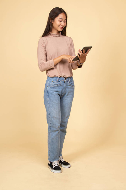 Full body of young Asian woman with a computer tablet. - Fotó, kép