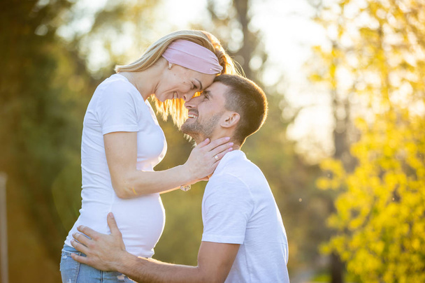 Happy couple expecting baby, pregnant woman with husband, young family and new life concept - Photo, image