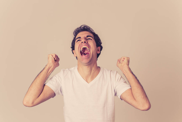 Portrait of very excites and shocked young man celebrating winning the lottery or having great success with surprised and happy gestures. In People, Facial Expression and Human Emotions. Studio shot. - 写真・画像
