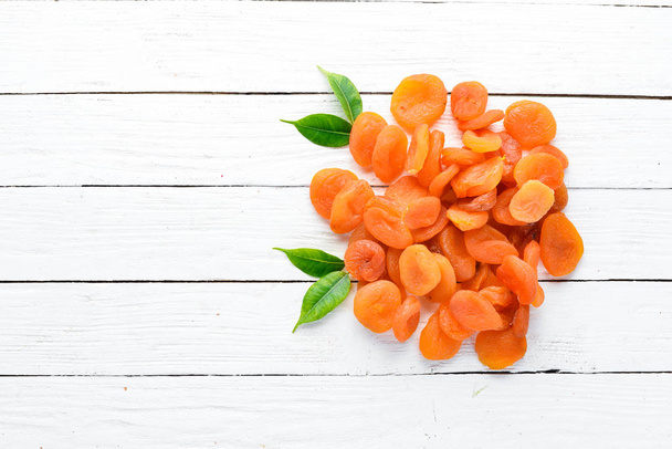 Dried apricots on a white wooden background. Dried fruit Top view. Free space for your text. - Fotografie, Obrázek