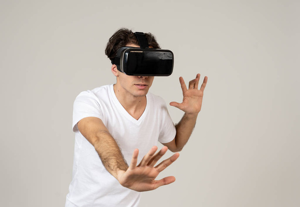 Amazed funny man using VR headset glasses touching and interacting with virtual reality world , feeling excited exploring and having fun in 360 VR simulation. Innovation and new technology concept. - Foto, afbeelding