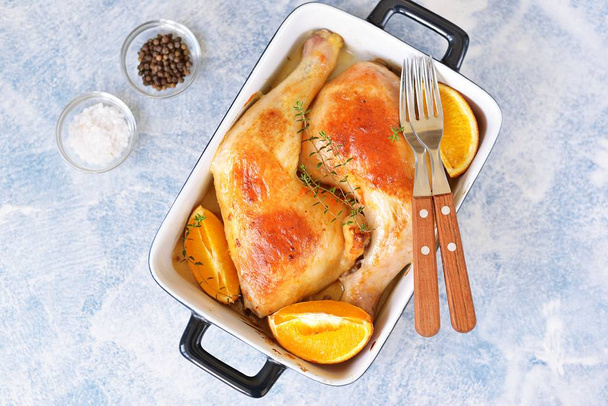 Chicken legs baked with orange slice and rosemary. Top view.  - Foto, Imagem