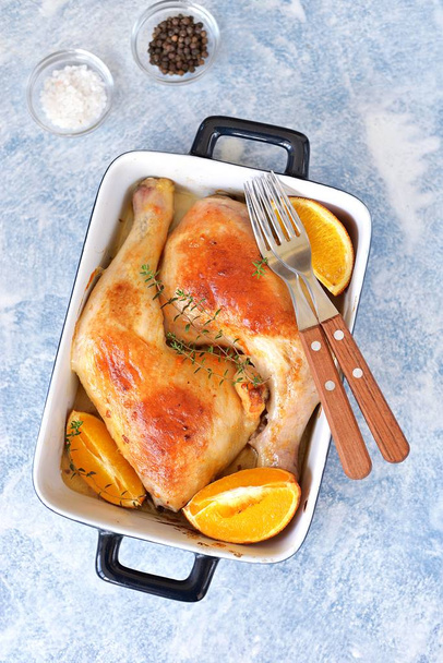 Chicken legs baked with orange slice and rosemary. Top view.  - Foto, Imagem