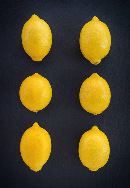 Шість свіжих лимонів на темному фоні
 - Фото, зображення