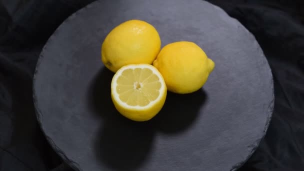 Siyah bir arka plan üzerinde olgun taze sulu sarı limon döndürmek. - Video, Çekim