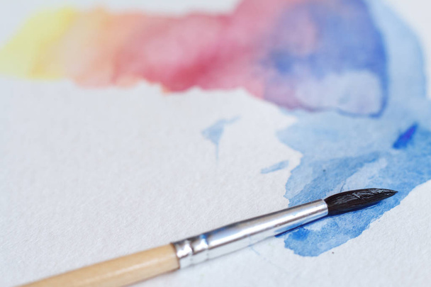 Close-up of beautiful watercolor brushstrokes on a white sheet, a brush in the picture - Fotó, kép
