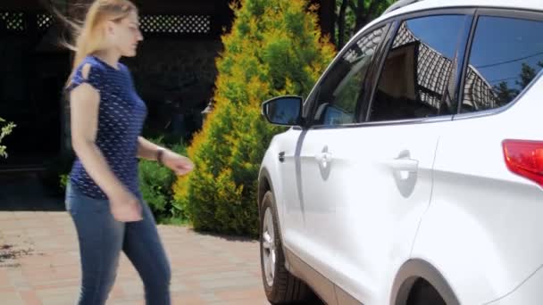 Videó a fiatal nő nyitja ajtót neki SUV autó és ülőhely a járművezetők ülés - Felvétel, videó