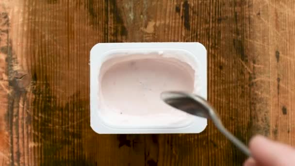 Eating Yogurt In Plastic Jar With Tea Spoon. Table Top View, Healthy Eating, Healthy Lifestyle - Filmati, video