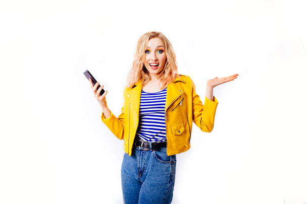  Girl in a bright yellow jacket makes a selfie for social networks on the smartphone. - Foto, Imagem