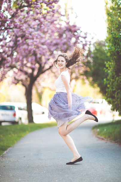 桜の木の下で踊る少女. - 写真・画像