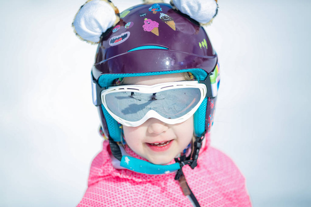 Portret cute Happy narciarz dziewczyna w kasku i gogle w ośrodku narciarskim zimą - Zdjęcie, obraz