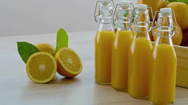 imagens de close-up de garrafas de suco de laranja na mesa branca
 - Filmagem, Vídeo