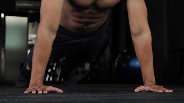 Handsome young Asian muscular sportsman doing push ups in gym, 60fps - Filmagem, Vídeo
