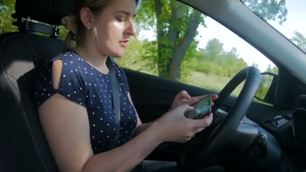 Slow Motion wideo nieodpowiedzialne i nieostrożne kobieta wpisując wiadomość na smartphone podczas jazdy samochodem. Proszę używać zestawu głośnomówiącego w pojeździe dla bezpieczeństwa - Materiał filmowy, wideo