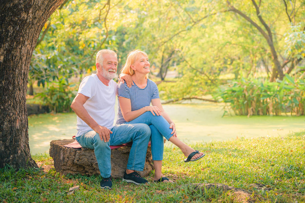 Ein älteres Ehepaar genießt den Sonnenuntergang im Garten. Konzept Paar ältere Liebe. - Foto, Bild