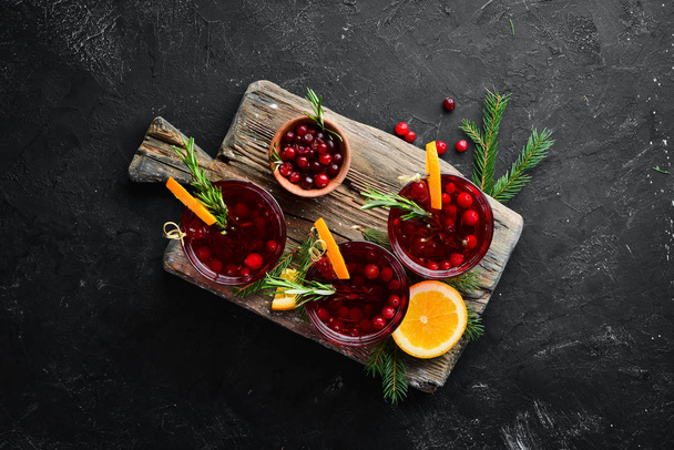 Glasses with cranberry juice. Cranberries, limes, rosemary. On a rustic background. Top view. Free space for your text. - Foto, afbeelding