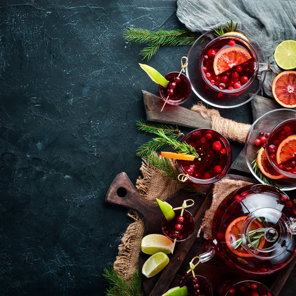 Cocktails and drinks with cranberries. Cranberries, limes, rosemary. On a black background. Top view. Free space for your text. - Φωτογραφία, εικόνα