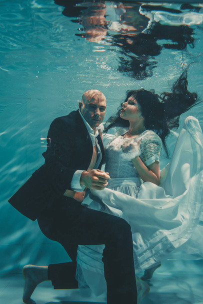 красива романтична пара нареченого і нареченого після весілля плаває м'яко під водою і розслабляється
 - Фото, зображення