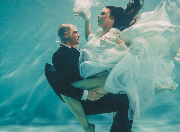 beau couple romantique de mariés après mariage nageant doucement sous l'eau et se détendre
 - Photo, image