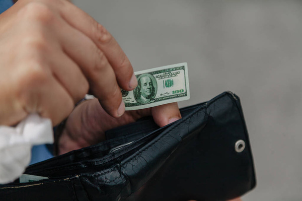 Hand puts toy banknote into wallet - Foto, Imagen